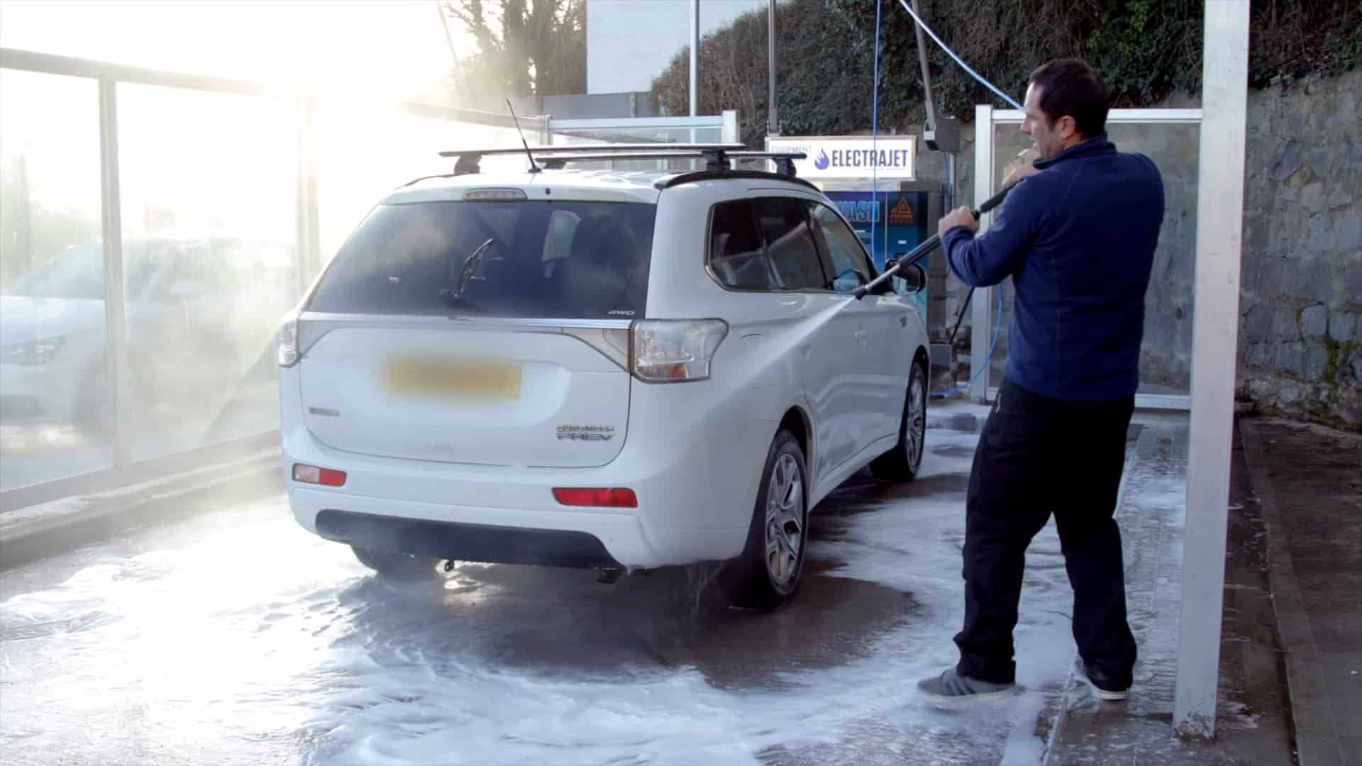 man washing a car with an jet wash
