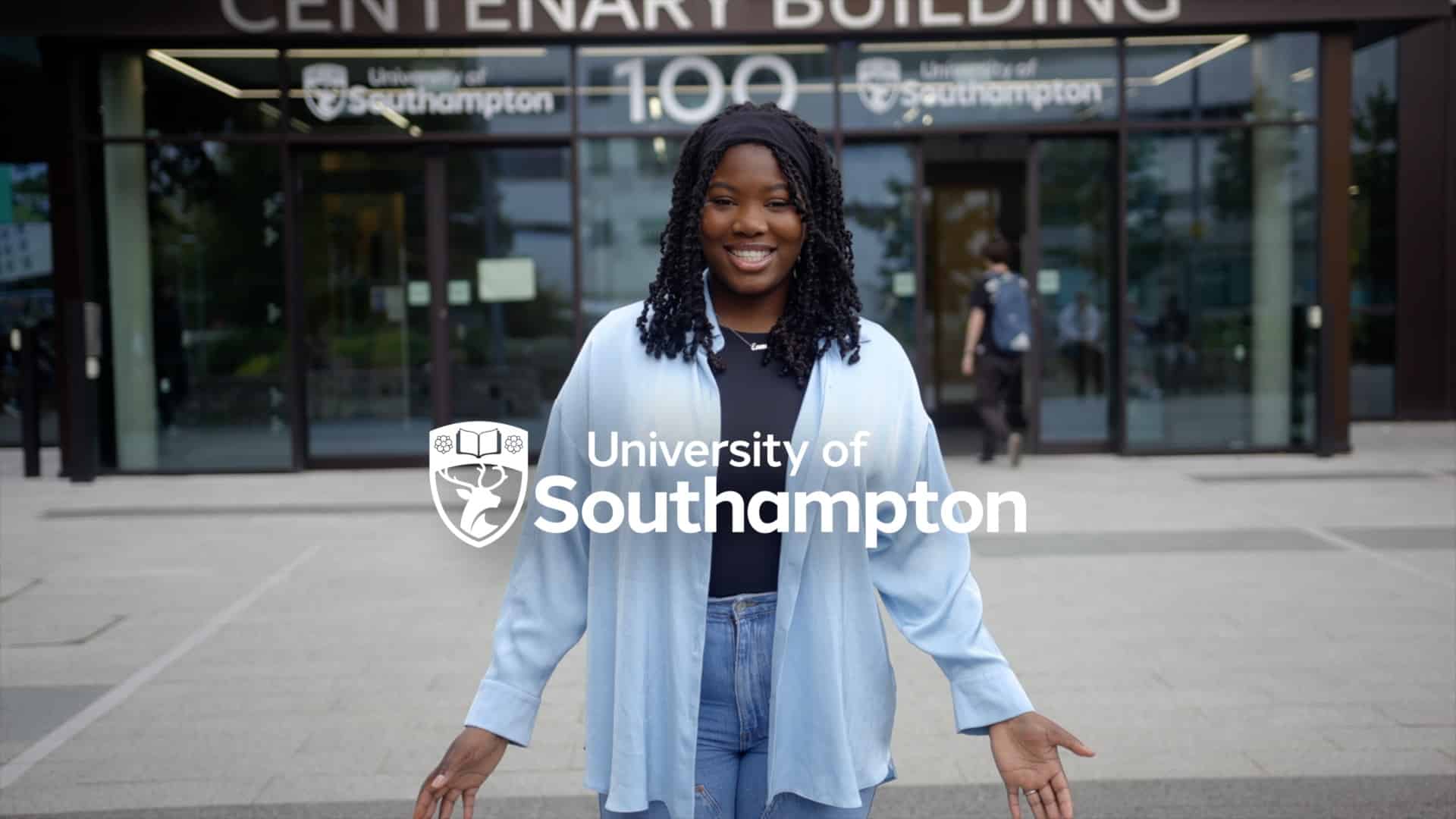 A smiling young woman with shoulder-length braided hair, stands in front of the University of Southampton's Centenary Building entrance. She's wearing a light blue overshirt, dark top, and jeans. In the foreground, the university's logo and name overlay the image.