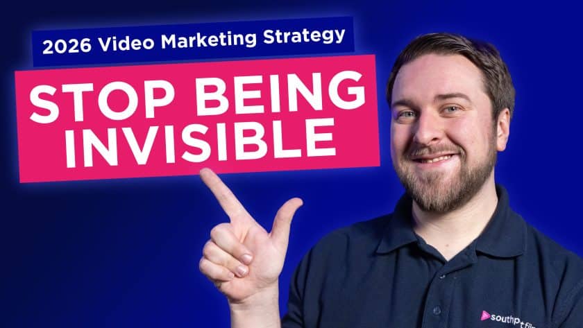 A smiling person with brown hair and a beard points toward large text boxes reading "2026 Video Marketing Strategy" and "STOP BEING INVISIBLE" on a blue background.